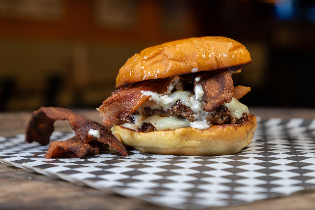 The Cowgirl - Two American Wagyu beef patties, bacon, white American cheese, and horseradish aioli on a Martin's potato bun.