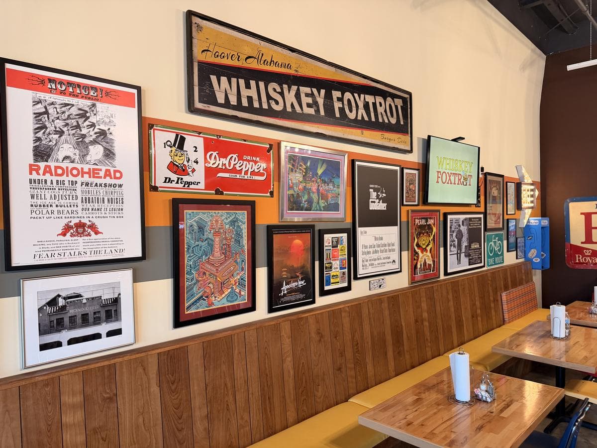 Inside the new Whiskey Foxtrot Hoover: the poster wall and the Hoover, Alabama sign above the booths