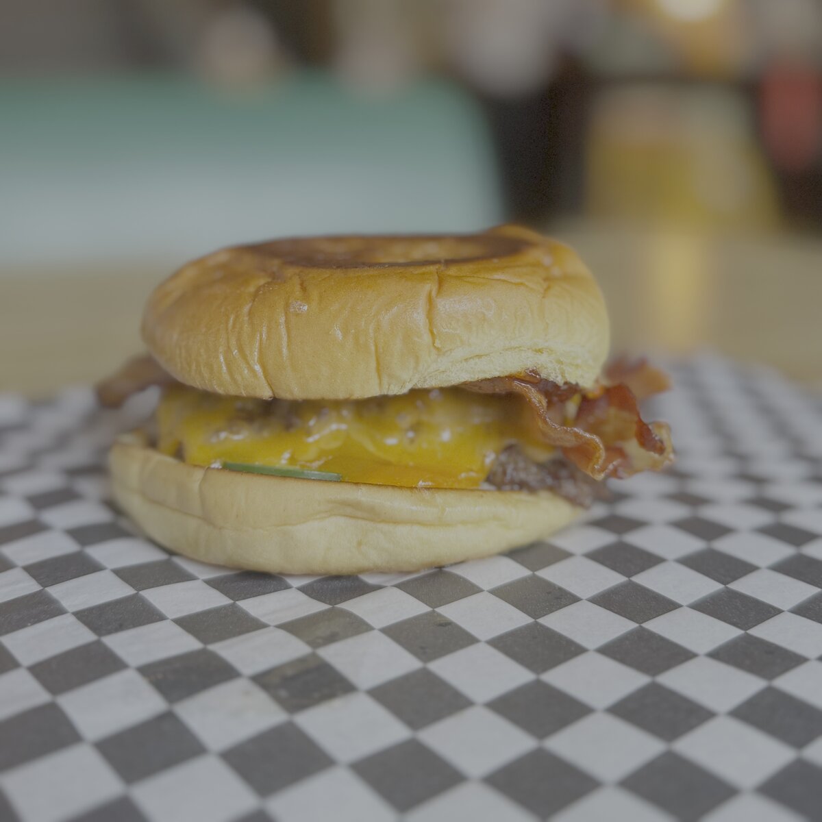 The Patriot - Two American Wagyu beef patties, two slices of cheddar cheese, bacon, habanero bacon jam, fresh jalapeños, and mayo on a Martin's potato bun.